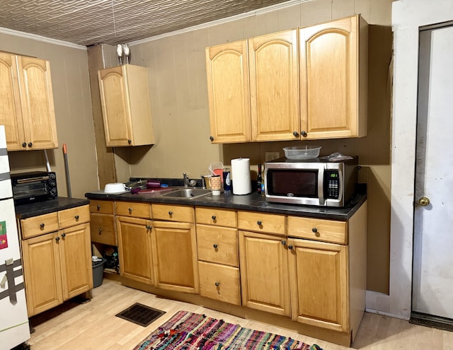 58 Elm St, Old Town, ME 04468 - kitchen with stainless steel microwave, crown molding, dark countertops, and light wood-style flooring