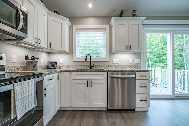 144 Ridley Rd, Sanford, ME 04073 - kitchen with stainless steel appliances, wood finished floors, white cabinetry, light stone counters, and recessed lighting