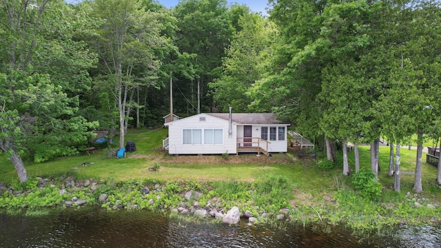 19 Davis Ln, Burnham, ME 04922 - view of front of property with a deck with water view, a forest view, and a front yard