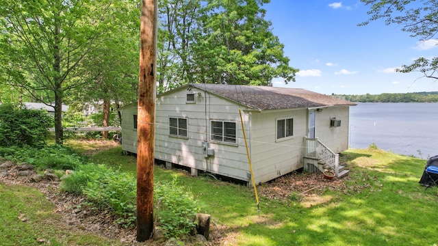 19 Davis Ln, Burnham, ME 04922 - view of side of home with a water view, a shingled roof, a yard, and entry steps