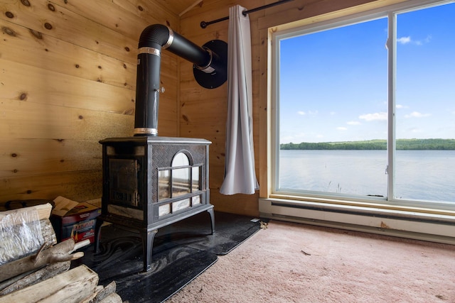 19 Davis Ln, Burnham, ME 04922 - detailed view of a wood stove, carpet flooring, nearby water, wood walls, and baseboard heating