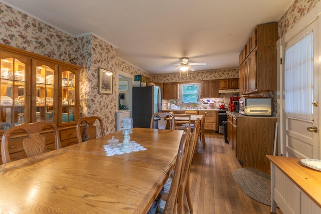 6 Paddy Ln, Franklin, ME 04634 - dining room with wallpapered walls, wood-type flooring, ceiling fan, and crown molding
