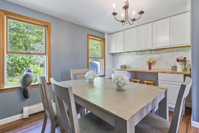104 Chick Rd, Lebanon, ME 04027 - dining space featuring wood finished floors, a chandelier, and baseboard heating