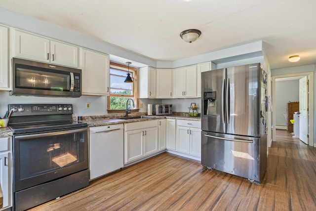 104 Chick Rd, Lebanon, ME 04027 - kitchen featuring appliances with stainless steel finishes, wood finished floors, white cabinetry, and a baseboard heating unit