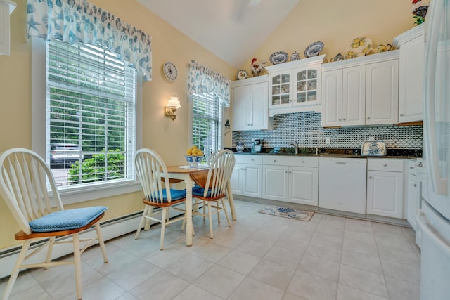 86 Farragut Way Unit 86, Kennebunk, ME 04043 - kitchen with white dishwasher, dark countertops, tasteful backsplash, vaulted ceiling, and white cabinetry