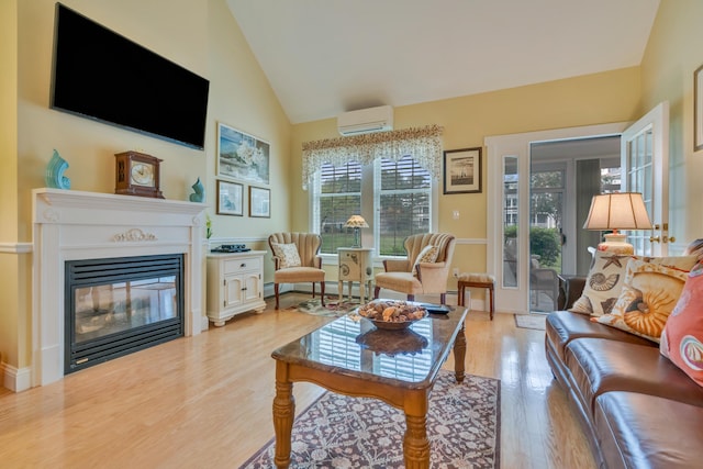 86 Farragut Way Unit 86, Kennebunk, ME 04043 - living room featuring a wall unit AC, plenty of natural light, light wood-style floors, a glass covered fireplace, and high vaulted ceiling
