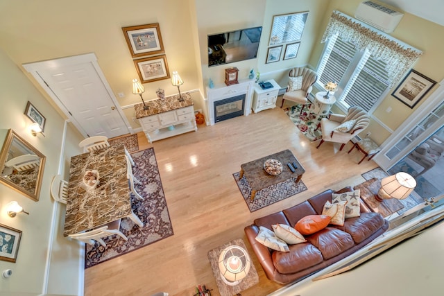 86 Farragut Way Unit 86, Kennebunk, ME 04043 - living room with a wall mounted air conditioner, wood finished floors, and a glass covered fireplace