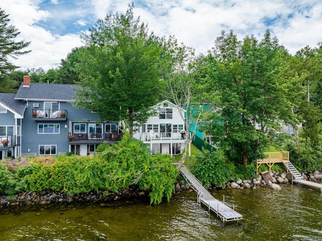 23 Page Rd, Enfield, ME 04493 - rear view of house with stairway, a chimney, a balcony, a water view, and view of scattered trees