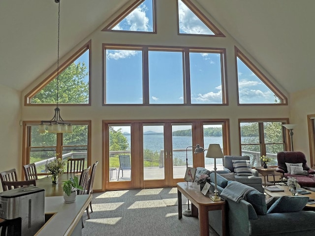 31 Deer Run, Lamoine, ME 04605 - carpeted living room with high vaulted ceiling, a water view, french doors, and healthy amount of natural light