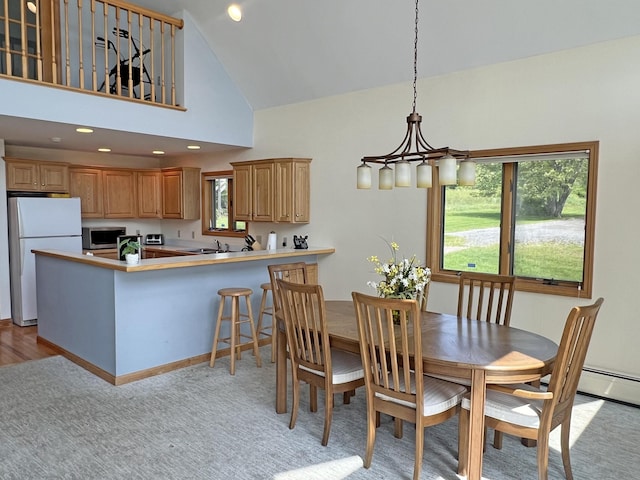 31 Deer Run, Lamoine, ME 04605 - dining room with a chandelier, high vaulted ceiling, light carpet, and a baseboard radiator