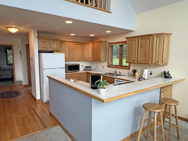 31 Deer Run, Lamoine, ME 04605 - kitchen with stainless steel microwave, freestanding refrigerator, a peninsula, a breakfast bar, and light countertops