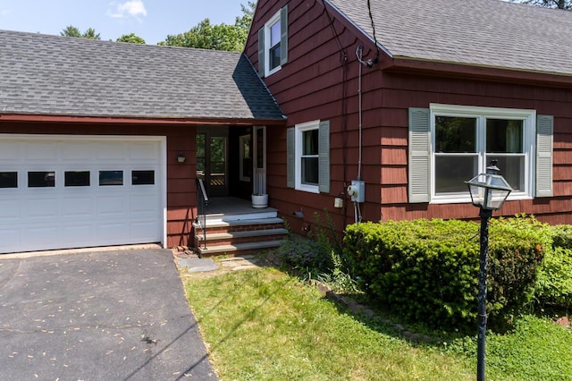 69 Garfield Rd, Auburn, ME 04210 - view of front of house with a shingled roof, an attached garage, and asphalt driveway