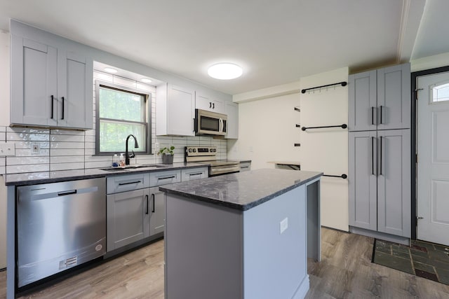 9 Jean St, Kittery, ME 03904 - kitchen with appliances with stainless steel finishes, light wood-type flooring, a center island, gray cabinetry, and decorative backsplash