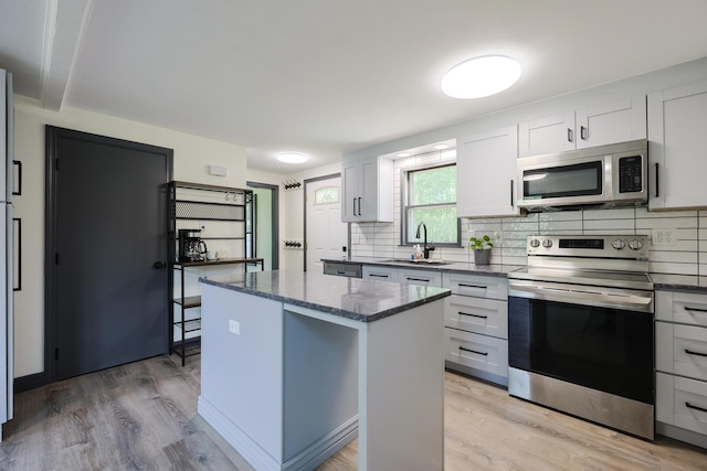 9 Jean St, Kittery, ME 03904 - kitchen with stainless steel appliances, a kitchen island, tasteful backsplash, and light wood-style floors