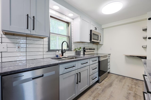 9 Jean St, Kittery, ME 03904 - kitchen featuring stainless steel appliances, backsplash, dark stone counters, and light wood-type flooring