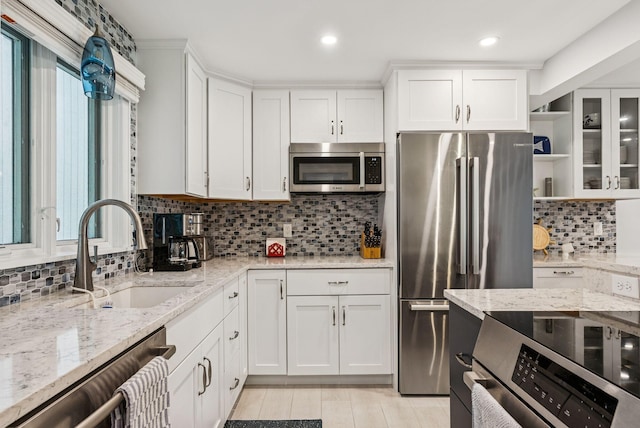 135 Ocean Ave Unit 15, Kennebunkport, ME 04046 - kitchen with appliances with stainless steel finishes, white cabinets, tasteful backsplash, light stone counters, and recessed lighting