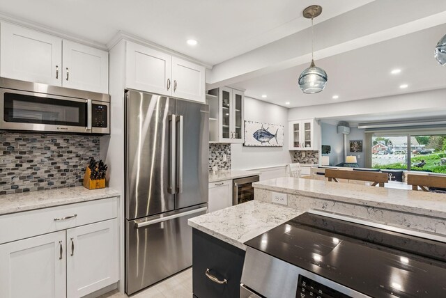 135 Ocean Ave Unit 15, Kennebunkport, ME 04046 - kitchen with stainless steel appliances, beverage cooler, white cabinetry, glass insert cabinets, and recessed lighting
