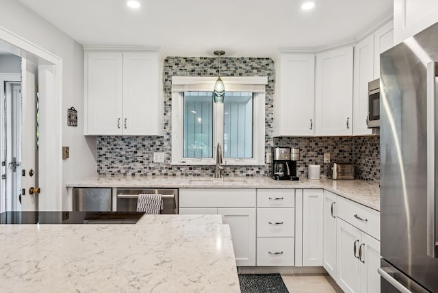 135 Ocean Ave Unit 15, Kennebunkport, ME 04046 - kitchen with stainless steel appliances, white cabinets, decorative backsplash, and recessed lighting