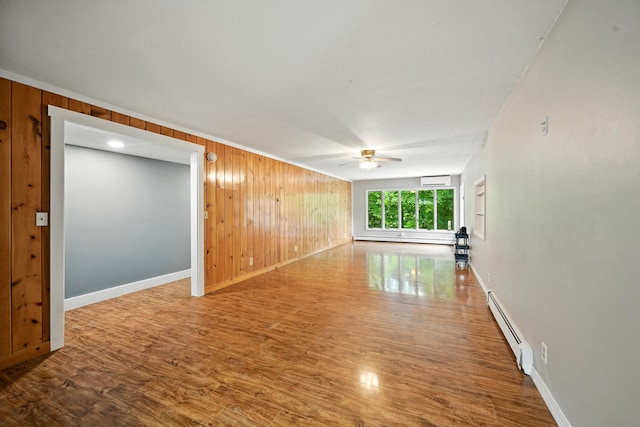 22 Sanborn Cir, Norway, ME 04268 - empty room featuring a baseboard heating unit, a ceiling fan, wood walls, and wood finished floors
