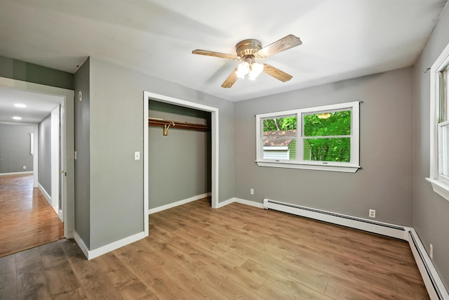 22 Sanborn Cir, Norway, ME 04268 - unfurnished bedroom featuring a baseboard radiator, wood finished floors, a closet, and a ceiling fan