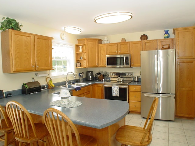 976 Essex St, Bangor, ME 04401 - kitchen with stainless steel appliances, a peninsula, a kitchen breakfast bar, and dark countertops
