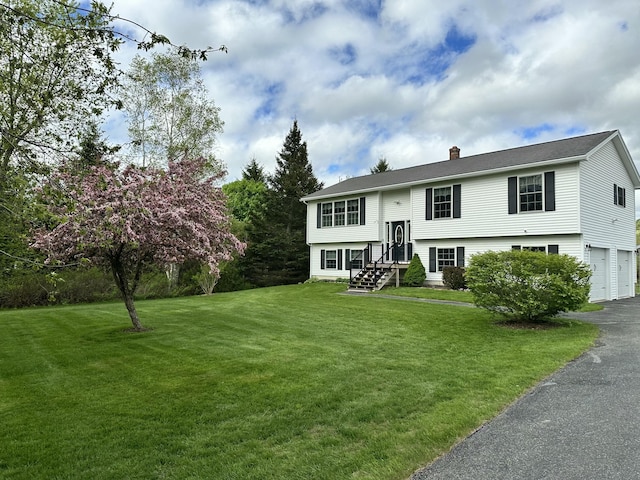 976 Essex St, Bangor, ME 04401 - raised ranch with a chimney, a front yard, an attached garage, and asphalt driveway