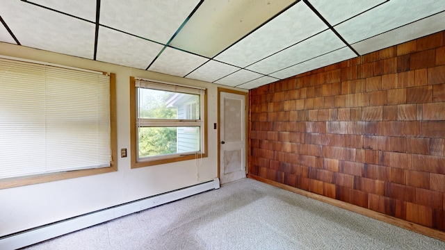 84 Elm St, Sabattus, ME 04280 - unfurnished room with a baseboard heating unit, light colored carpet, and wood walls