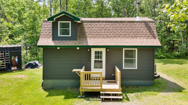 711 Stetson Rd, Exeter, ME 04435 - back of house with a shingled roof, a lawn, a deck, and view of scattered trees