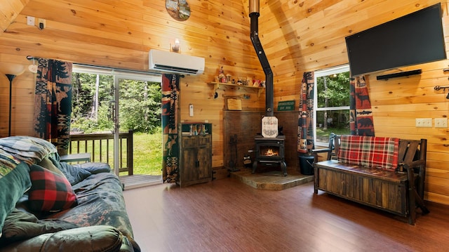 711 Stetson Rd, Exeter, ME 04435 - living area with a wall mounted air conditioner, a wood stove, wood finished floors, wood walls, and healthy amount of natural light