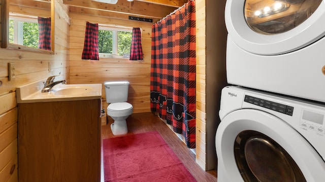 711 Stetson Rd, Exeter, ME 04435 - bathroom with stacked washer and clothes dryer, wooden walls, wood finished floors, vanity, and a shower with shower curtain