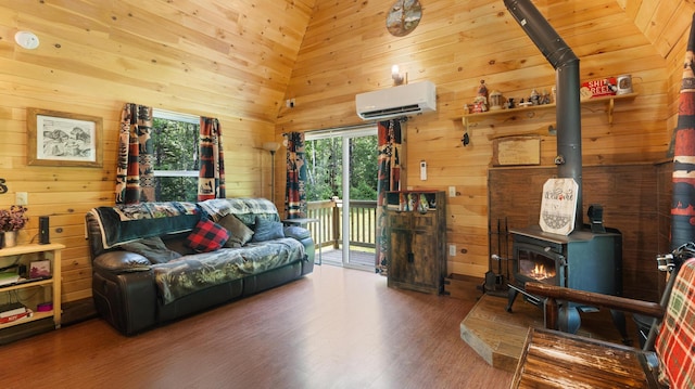 711 Stetson Rd, Exeter, ME 04435 - living area featuring a wall unit AC, a wood stove, wood walls, and wood finished floors
