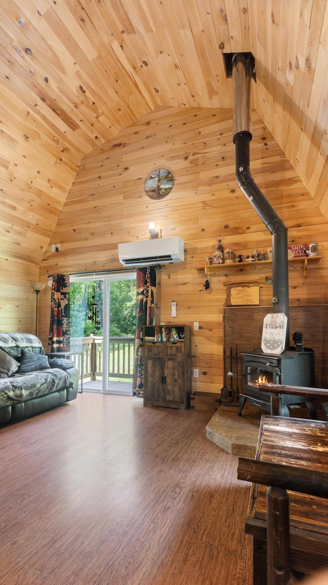 711 Stetson Rd, Exeter, ME 04435 - living area with wooden ceiling, a wall unit AC, wooden walls, a wood stove, and wood finished floors