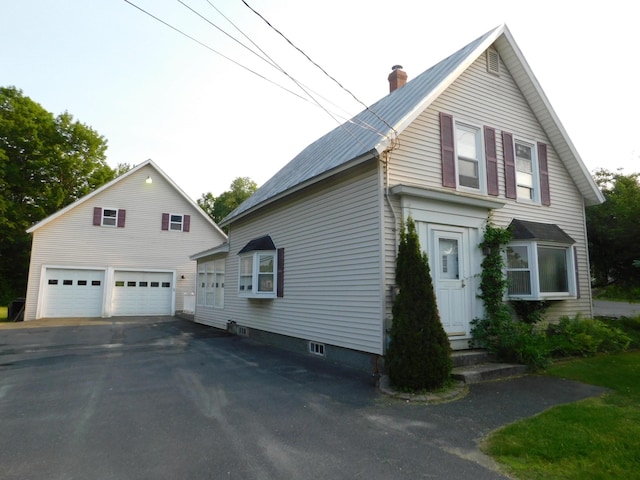 27 Main St, Norridgewock, ME 04957 - view of side of home featuring a garage, a chimney, a metal roof, and an outdoor structure