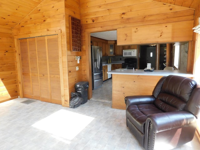 27 Main St, Norridgewock, ME 04957 - kitchen featuring white microwave, range, stainless steel refrigerator with ice dispenser, wooden walls, and vaulted ceiling