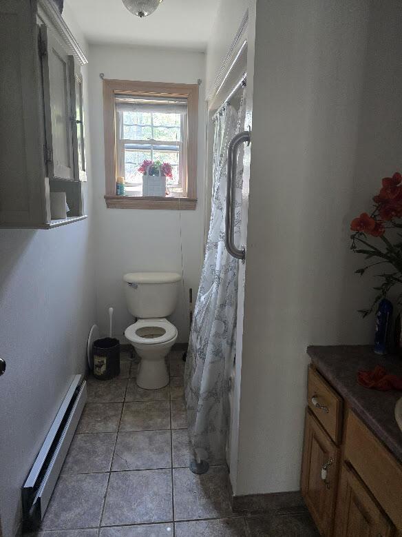 269 Bruckoff Rd, Clifton, ME 04428 - bathroom with a baseboard radiator, vanity, tile patterned floors, and curtained shower