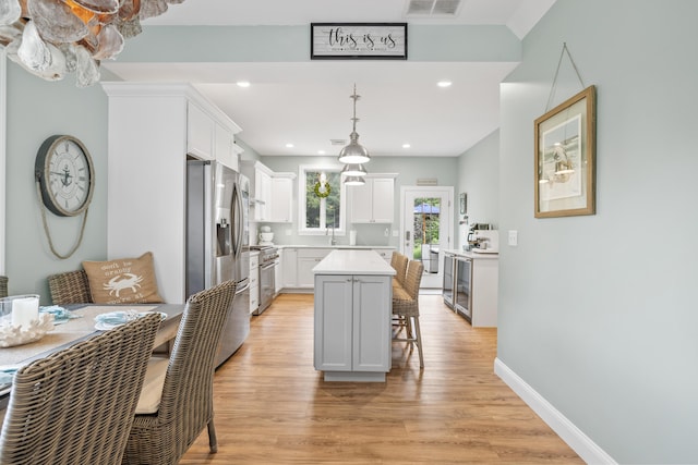 18 Frontier Way Unit 162, Arundel, ME 04046 - kitchen featuring appliances with stainless steel finishes, a breakfast bar, light wood-style flooring, a kitchen island, and light countertops