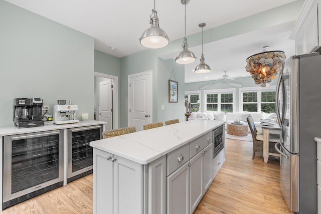 18 Frontier Way Unit 162, Arundel, ME 04046 - kitchen with appliances with stainless steel finishes, wine cooler, open floor plan, and a ceiling fan