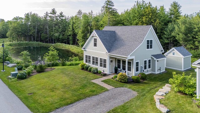18 Frontier Way Unit 162, Arundel, ME 04046 - view of front of house featuring a front yard, a shingled roof, an outdoor structure, and a view of trees