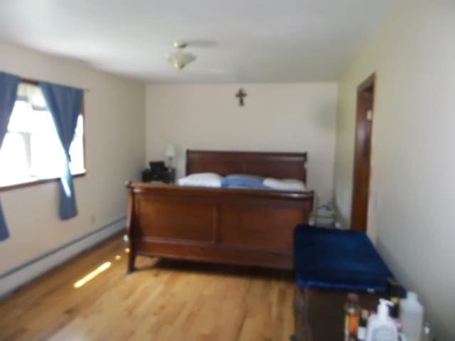 583 River Rd, Calais, ME 04619 - bedroom with light wood-style flooring and a baseboard heating unit