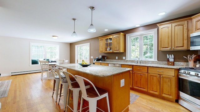 3 Marr Farm Way, Scarborough, ME 04074 - kitchen with appliances with stainless steel finishes, a baseboard radiator, light stone countertops, a center island, and a kitchen bar