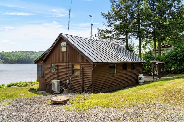 76 Colony Rd, Belgrade, ME 04917 - view of home's exterior with a standing seam roof, a metal roof, a water view, a yard, and log veneer siding