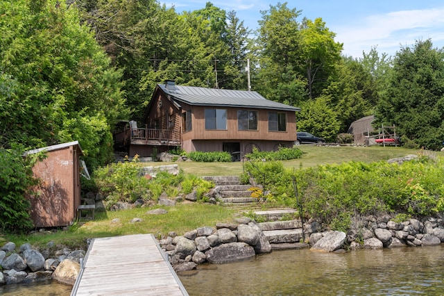 76 Colony Rd, Belgrade, ME 04917 - rear view of property with a metal roof, a standing seam roof, a lawn, a deck with water view, and a chimney