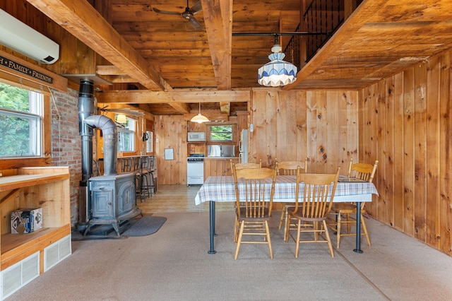 76 Colony Rd, Belgrade, ME 04917 - dining space featuring wood walls, a wall unit AC, a wood ceiling with exposed beams, a wood stove, and carpet flooring