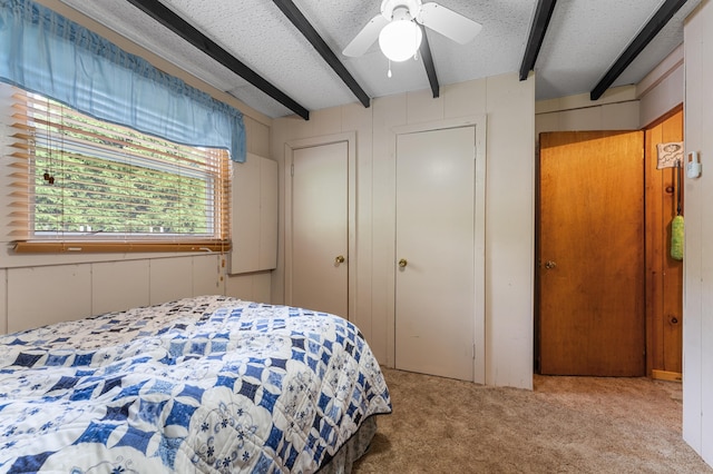 76 Colony Rd, Belgrade, ME 04917 - carpeted bedroom with beamed ceiling, a textured ceiling, a ceiling fan, a closet, and a decorative wall