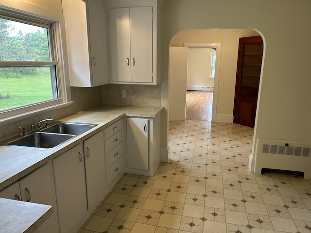 323 Montsweag Rd, Woolwich, ME 04579 - kitchen featuring baseboard heating, radiator, arched walkways, and light flooring