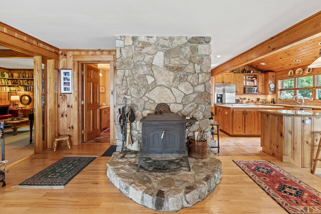 59 Wild Acres Rd, Raymond, ME 04071 - living area with wood walls, light wood-style floors, and a wood stove