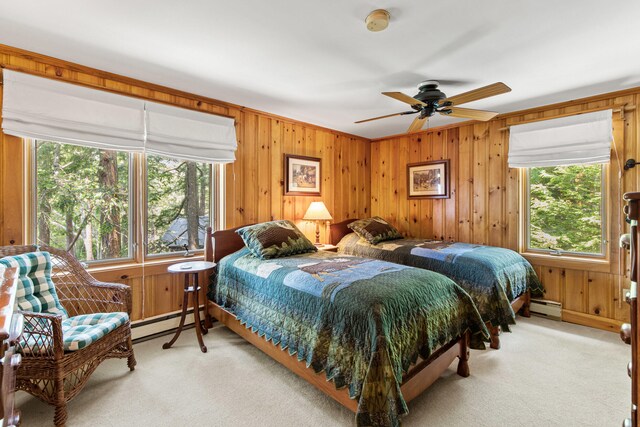 59 Wild Acres Rd, Raymond, ME 04071 - bedroom with a baseboard heating unit, light colored carpet, baseboard heating, wood walls, and ceiling fan