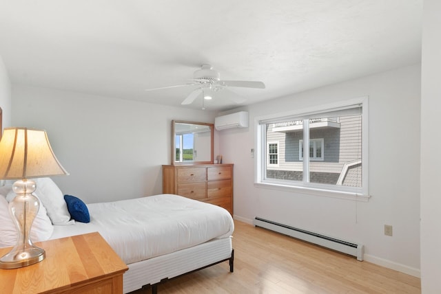 17 White Cap Ln, Wells, ME 04090 - bedroom featuring baseboard heating, an AC wall unit, light wood-style flooring, and a ceiling fan
