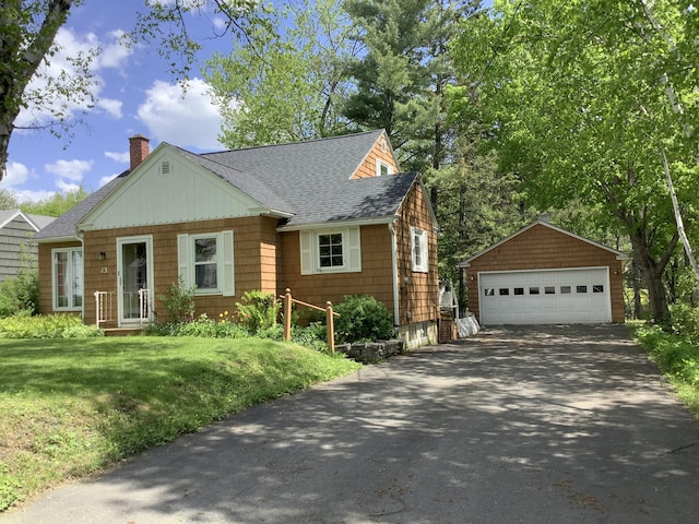 13 Elizabeth Ave, Caribou, ME 04736 - view of front of home featuring a detached garage, an outbuilding, roof with shingles, a chimney, and a front yard