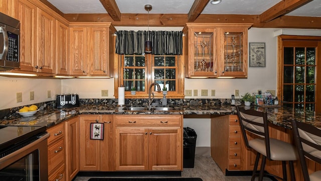 115 Fuller Ln, Denmark, ME 04022 - kitchen with stainless steel microwave, beam ceiling, brown cabinets, glass insert cabinets, and dark stone countertops